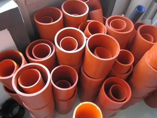 Different sizes of CPVC pipes are standing vertically on the ground, some nested inside each other.